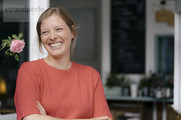 Porträt einer lachenden jungen Frau in einem Cafe