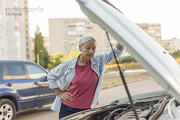 Ältere Frau betrachtet Automotor