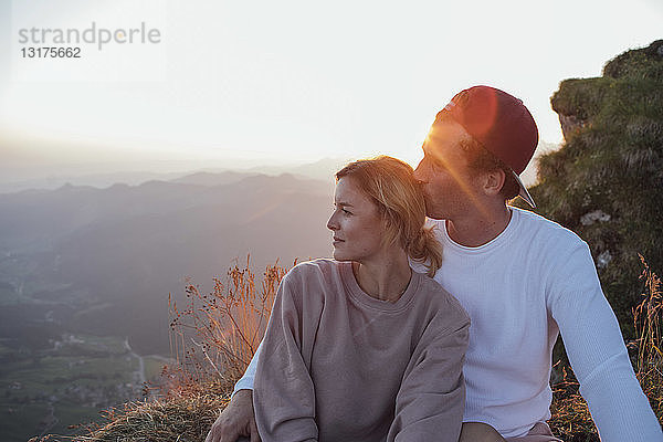 Schweiz  Grosse Mythen  junges Paar auf Wanderung mit Pause bei Sonnenaufgang