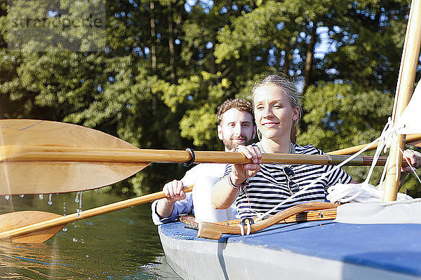 Junges Paar geniesst eine Kanufahrt auf einem See