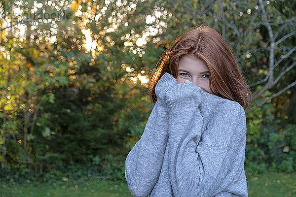 Porträt einer Teenagerin  die im Herbst einen grauen Pullover trägt