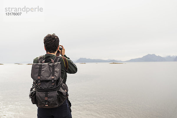 Junger Mann fotografiert einen See auf der Insel Vesteralen  Lappland  Norwegen