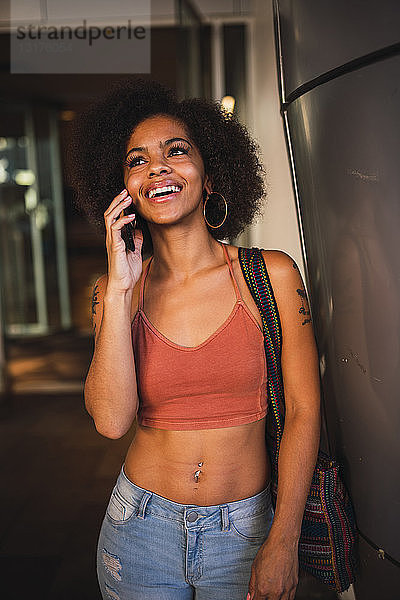 Porträt einer glücklichen jungen Frau am Handy
