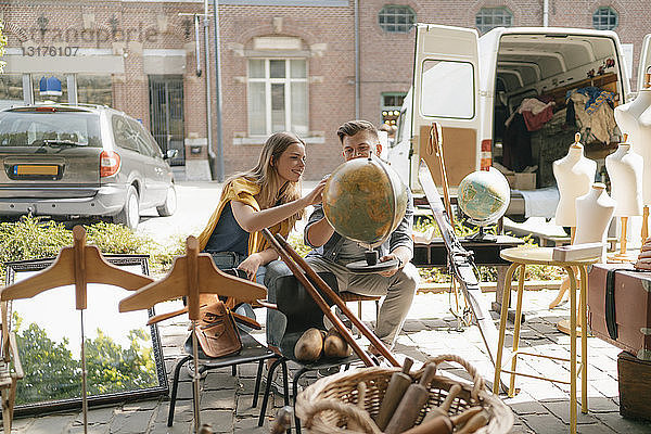 Belgien  Tongeren  junges Paar untersucht den Globus auf einem Antiquitäten-Flohmarkt