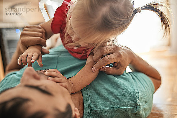 Vater und kleine Tochter spielen zu Hause zusammen