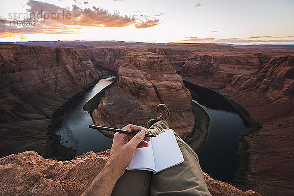 USA  Arizona  Colorado River  Horseshoe Bend  junger Mann auf Aussichtspunkt  Notizbuch