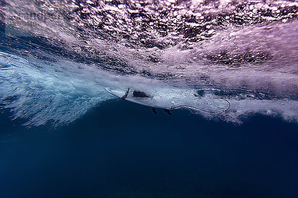 Malediven  Unterwasseransicht der Welle  Surfer auf dem Surfbrett sitzend  Unterwasserschuss