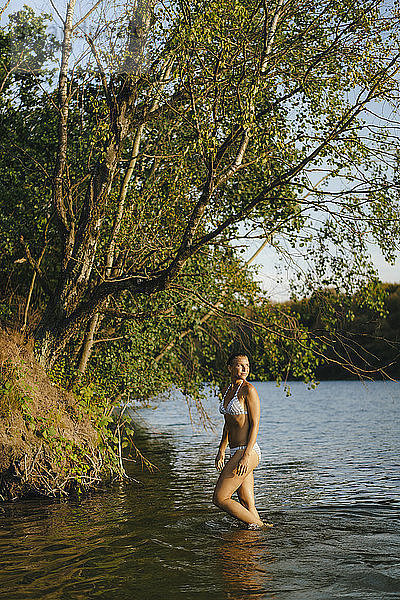 Frau im Bikini  die in einem See watend