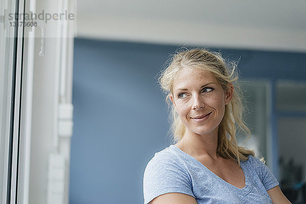 Porträt einer lächelnden blonden Frau  die zur Seite schaut