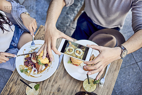 Draufsicht eines Paares  das im Restaurant im Freien Essen fotografiert