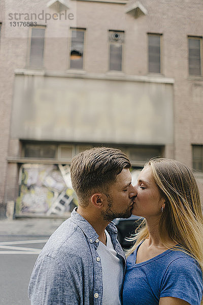 Zärtliches junges Paar küsst sich in der Stadt