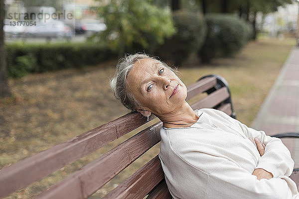 Porträt einer älteren Frau  die sich auf einer Bank entspannt