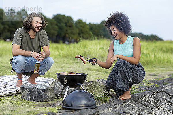 Glückliches Paar beim Grillen in der Natur