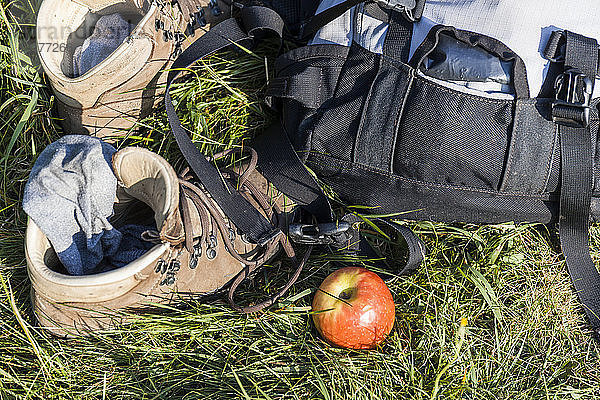 Wanderstiefel  Rucksack und Apfel auf einer Wiese