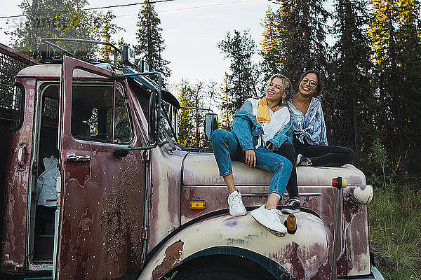 Zwei Freunde sitzen auf einem kaputten Lastwagen