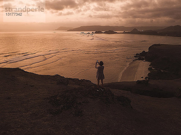 Indonesien  Lombok  junge Frau an der Küste bei Sonnenuntergang