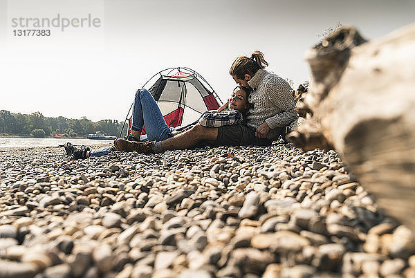 Glückliches junges Paar entspannt sich in einem Zelt am Flussufer
