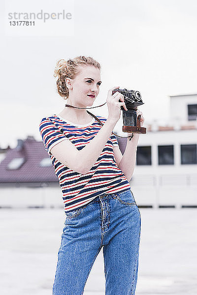 Porträt einer jungen Frau mit Oldtimer-Kamera