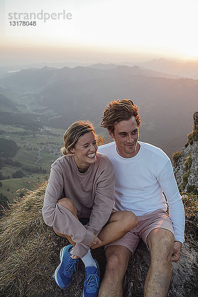 Schweiz  Grosse Mythen  glückliches junges Paar auf einer Wanderung mit Pause bei Sonnenaufgang
