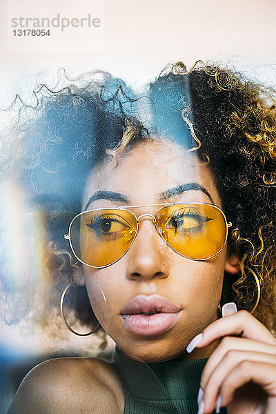 Porträt einer modischen jungen Frau mit gelber Sonnenbrille