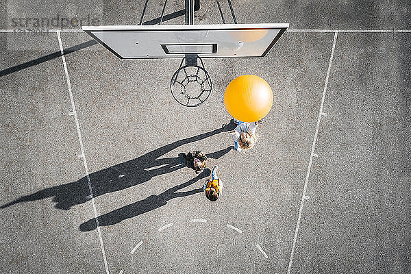 Österreich  Luftaufnahme eines Basketballfeldes  Mutter und Kinder spielen Basketball mit großem Ball