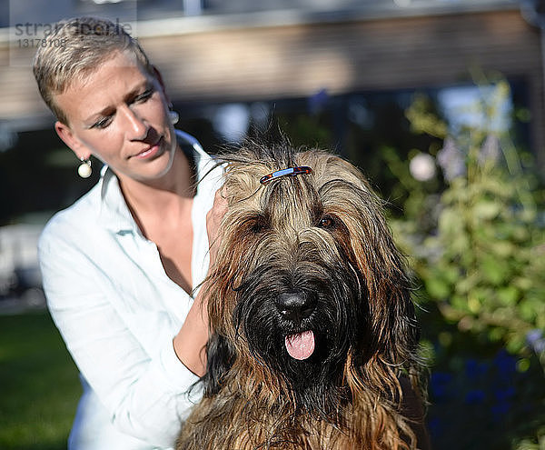 Porträt eines Hundes mit Haarspange mit Besitzer im Hintergrund