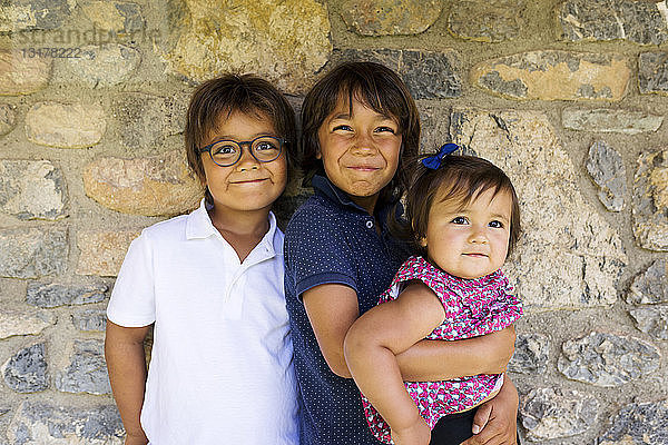 Porträt von zwei lächelnden Jungen und einem kleinen Mädchen