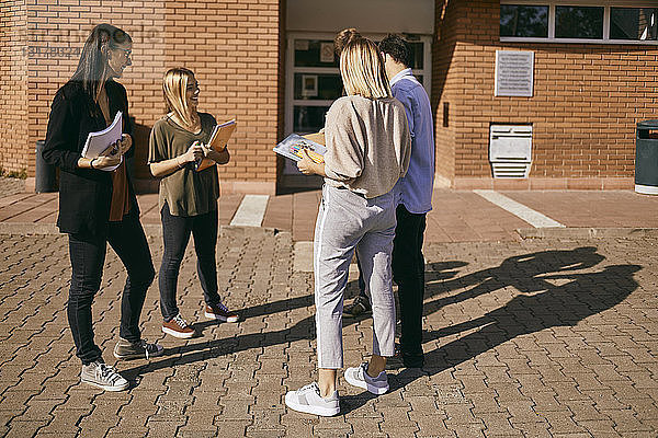 Gruppe von Studenten  die mit Dokumenten im Freien stehen