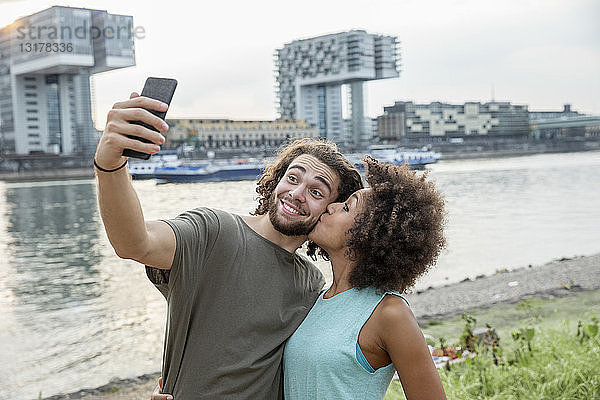 Deutschland  Köln  glückliches Paar beim Egoismus am Flussufer