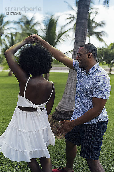 USA  Florida  Miami Beach  glückliches junges Paar tanzt im Sommer in einem Park