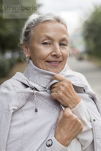 Porträt einer lächelnden älteren Frau mit Mantel