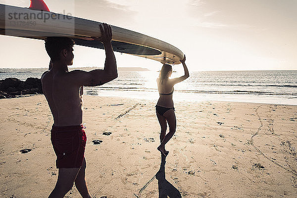 Frankreich  Bretagne  junges Paar mit einem SUP-Board gemeinsam am Strand