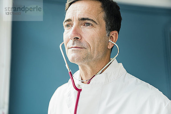 Porträt eines Arztes mit seitlich schauendem Stethoskop