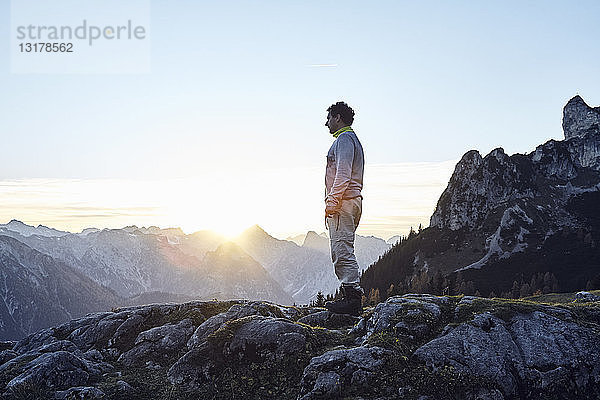 Österreich  Tirol  Rofangebirge  Wanderer bei Sonnenuntergang auf Felsen stehend