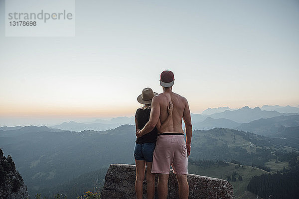 Schweiz  Grosse Mythen  junges Paar auf einer Wanderung bei Sonnenaufgang mit Blick auf die Aussicht