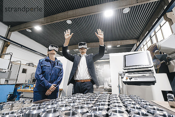 Geschäftsmann und Facharbeiter in einem High-Tech-Unternehmen  der eine VR-Brille benutzt