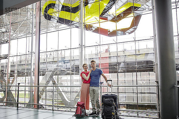 Lächelndes Paar steht auf dem Flughafen