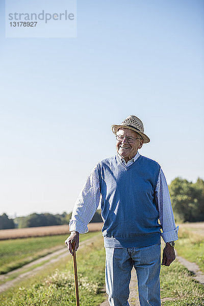 Älterer Mann mit Spazierstock  Spaziergang auf den Feldern