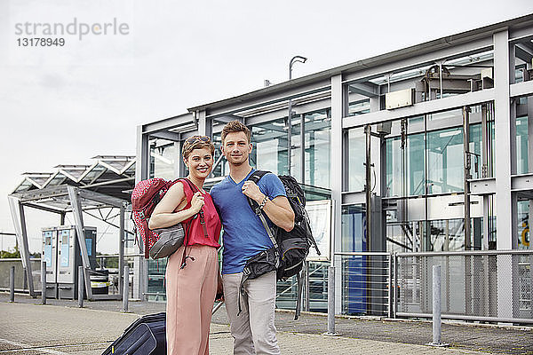 Porträt eines lächelnden Paares vor dem Flughafen