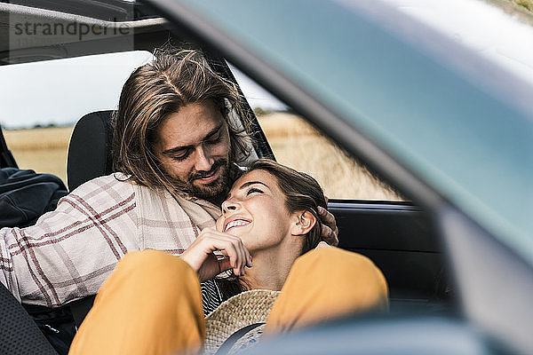 Glückliches  liebevolles junges Paar in einem Auto