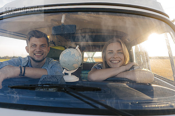 Porträt eines glücklichen jungen Paares auf einer Reise im Wohnmobil