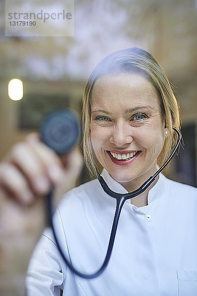 Porträt einer lächelnden Ärztin  die ein Stethoskop hält