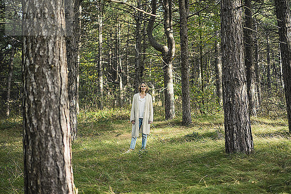 Gelassene Frau steht im Wald