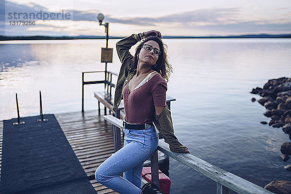 Hübsche junge Frau posiert auf einem Pier am Inari-See  Finnland