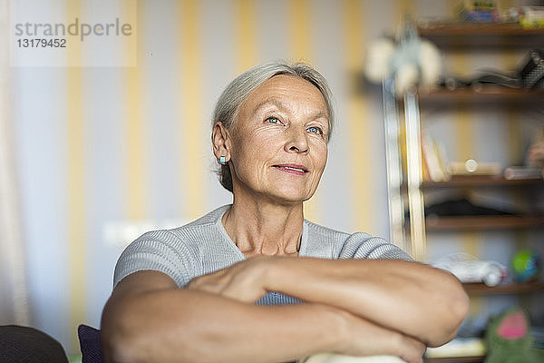 Porträt einer lächelnden älteren Frau  die sich zu Hause entspannt