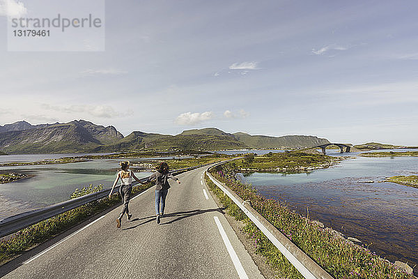 Junge Frauen gehen auf einer leeren Straße  Lappland  Norwegen