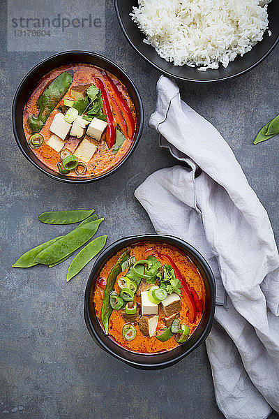 Zwei Schüsseln rotes Thai-Curry mit Zuckerschoten  Karotten  Paprika  Frühlingszwiebeln und geräuchertem Tofu