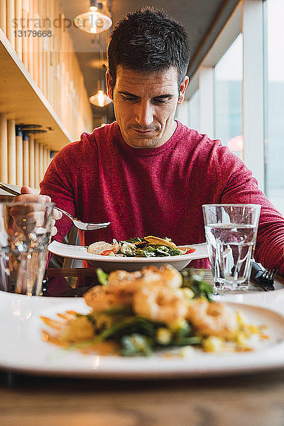 Geschäftsmann isst Salat in einem Restaurant