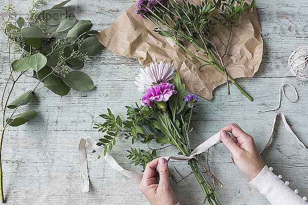 Frau bindet Blumenstrauss von Hand