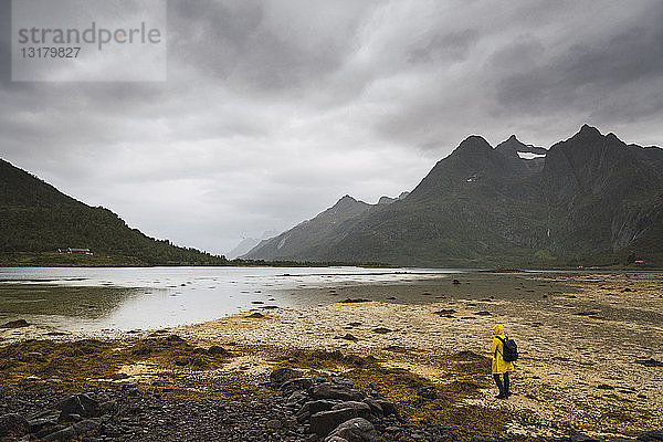 Junger Mann steht an einem See auf der Insel Vesteralen  Lappland  Norwegen